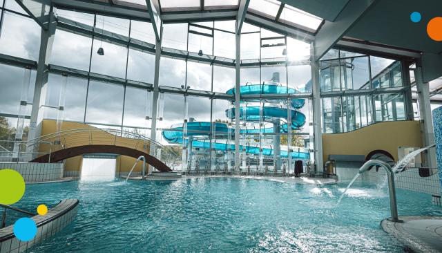 Hallenbadansicht mit Blick auf die Riesenrutsche im Außenbereich